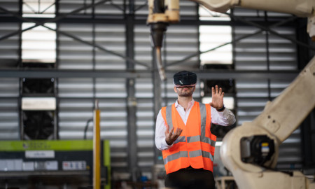 Close-up Shot of a Futuristic Robotic Arm Controlled by Professional Development Engineer with Virtual Reality Headset and Joysticks in a High Tech Research Laboratory with Modern Equipment