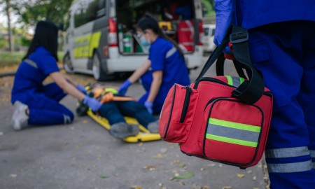 Selective focus is first aid bag. Team paramedic firs aid accident on road. Ambulance emergency service. First aid procedure.