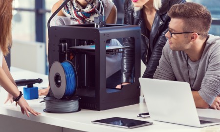 Start-up business team working together in the office, using a 3D printer.