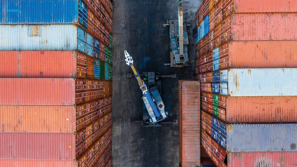 Container loading in cargo container in shipping yard with Forklift truck, Aerial top view.